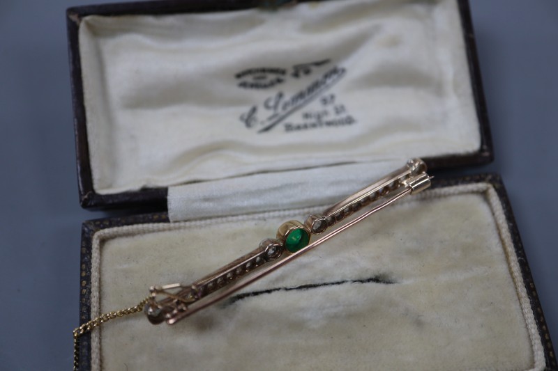 An early 20th century yellow metal, cabochon emerald and millegrain set diamond bar brooch, 52mm, gross 3.6 grams.